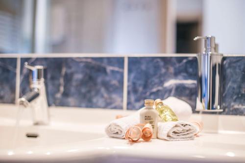 a bathroom sink with towels and a mirror at Hotel Marica in Eggen