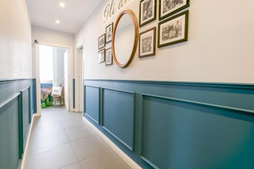 a hallway with a blue wall and a mirror at Family Affair Luxury Rooms&Suites in Palermo