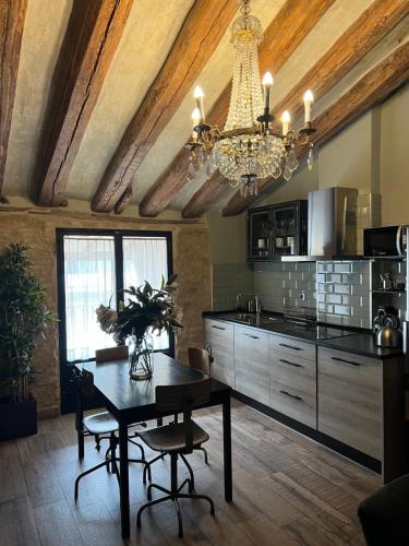 a kitchen with a dining table and a chandelier at Apartamentos Basilicus in Zaragoza