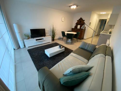 sala de estar con sofá y mesa en Gezellig modern appartement met optie garagebox en in de buurt van strand, winkels en restaurants en Ostende