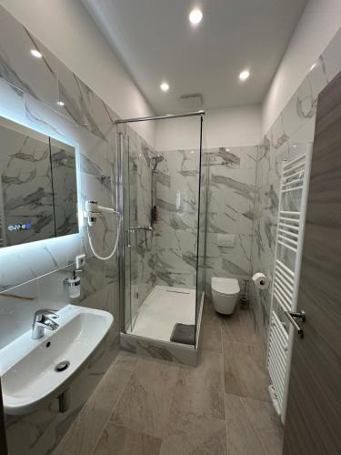 La salle de bains est pourvue d'une douche, d'un lavabo et de toilettes. dans l'établissement City Apartments - Nürnberg Altstadt, à Nuremberg