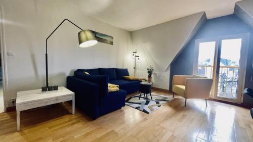 uma sala de estar com um sofá azul e uma mesa em Bel appartement au coeur du quartier des artistes em Camaret-sur-Mer