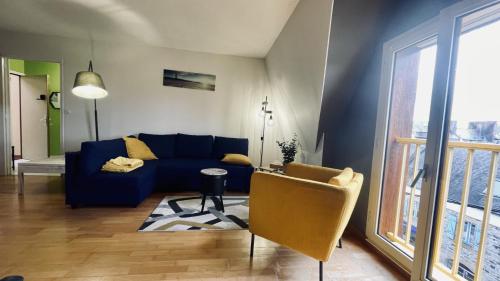 uma sala de estar com um sofá azul e uma janela em Bel appartement au coeur du quartier des artistes em Camaret-sur-Mer