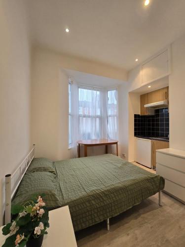 a bedroom with a bed and a desk in it at RELAKS LETTINGS in London