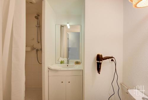 a white bathroom with a sink and a mirror at Le Caducé / Proche Deux Lions in Tours