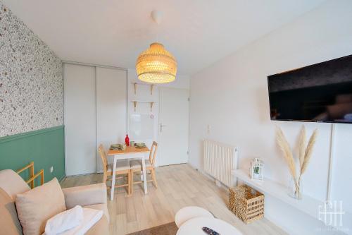 un salon avec une table et une télévision dans l'établissement Le Caducé / Proche Deux Lions, à Tours