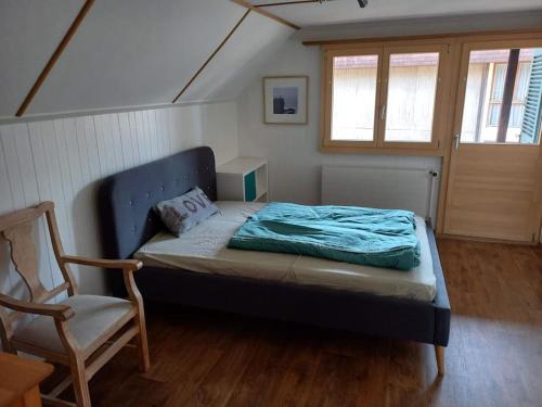 a bedroom with a bed and a chair in it at Chalet Bärenhaus in Sigriswil