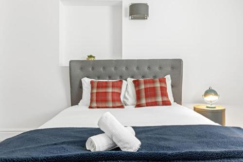 a bedroom with a large bed with towels on it at Luxurious 3 Bedroom Apartment in Park Estate in Nottingham