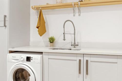 a kitchen with a sink and a washing machine at Luxurious 3 Bedroom Apartment in Park Estate in Nottingham