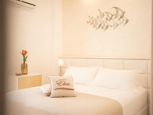 - un lit blanc avec un oreiller en coca cola dans l'établissement Albergo Elea, à Ascea