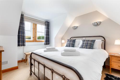 Un dormitorio con una cama grande y una ventana en The Neuk 4 miles to St Andrews, en Strathkinness