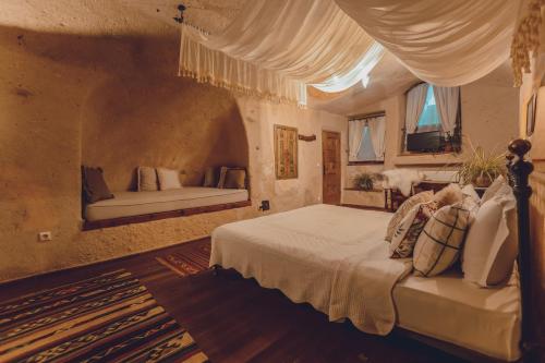 a bedroom with a bed and a couch in it at Kale Konak Cappadocia in Uchisar