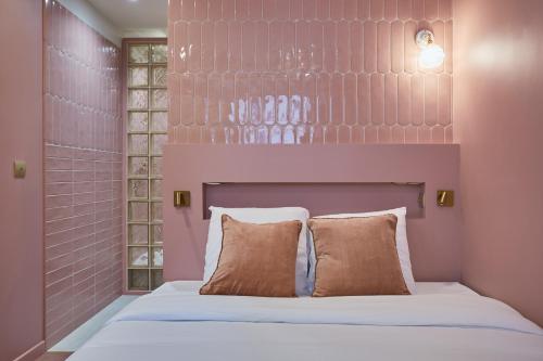 une chambre rose avec un lit et une tête de lit dans l'établissement Apartment Center of Paris by Studio prestige, à Paris