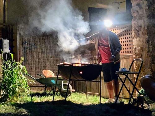 a man is cooking food on a grill at Casa David in Santa Liña