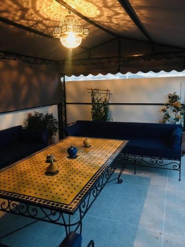 - une table et un banc dans une pièce dotée d'un lustre dans l'établissement Appartement atypique et lumineux, à Agadir