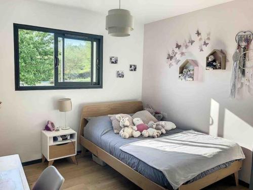 une chambre avec un lit avec des animaux en peluche dessus dans l'établissement Magnifique Villa Piscine, Salle Cinema Est Toulouse, à Sainte-Foy-dʼAigrefeuille