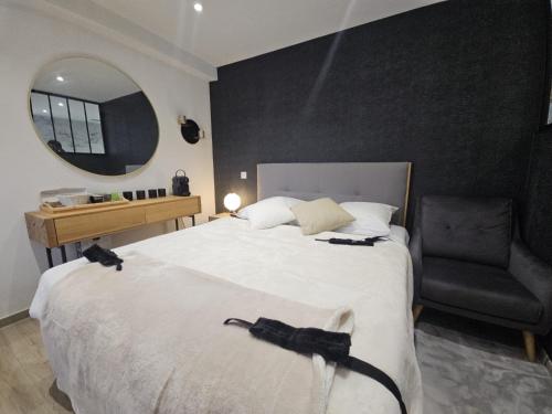 a bedroom with a bed with a chair and a mirror at Secret Room Spa Agde in Agde