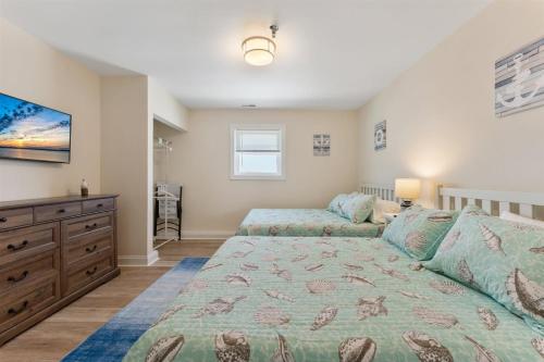 a bedroom with a bed and a dresser and a tv at 6109 Atlantic Ave, Unit 403 - The Cape Cod in Wildwood