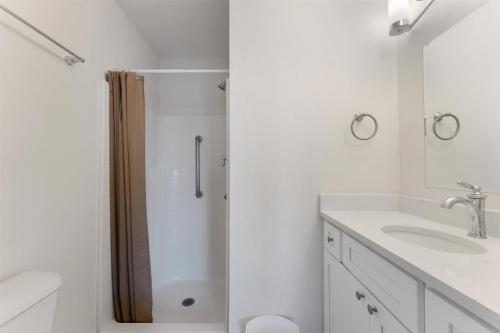 a white bathroom with a shower and a sink at 6109 Atlantic Ave, Unit 403 - The Cape Cod in Wildwood