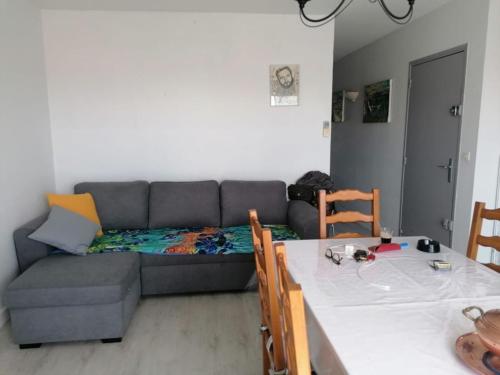 een woonkamer met een bank en een eettafel bij Le sagittaire in Port-la-Nouvelle