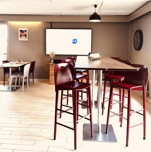 a conference room with a table and chairs and a projection screen at Campanile Dax - Saint-Paul-Les-Dax in Saint-Paul-lès-Dax