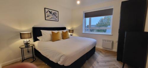 a bedroom with a bed with yellow pillows and a window at Hybrid Resi - Mitcham close to Tooting and Wimbledon in Mitcham