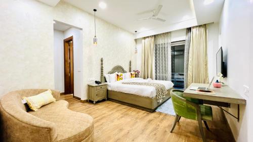 Olive Service Apartments - Medanta Medicity في جورجاون: غرفة نوم بسرير ومكتب واريكة