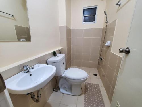 a bathroom with a toilet and a sink at COZY STUDIO DELUXE with Pool, Free Parking & Basket Ball Court , Pet Friendly Condo in Manila