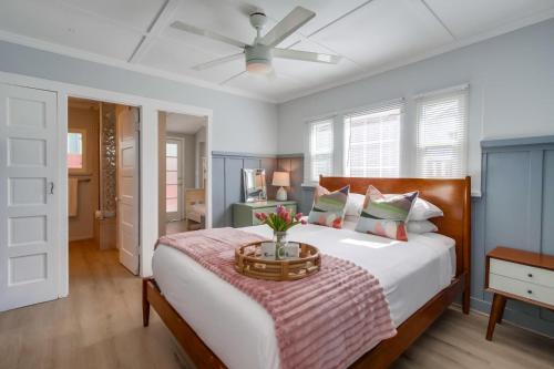 Ocean Beach Cottage في سان دييغو: غرفة نوم بسرير ومروحة سقف