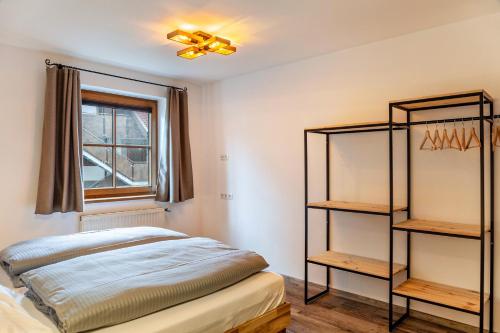 a bedroom with a bed and a window and shelves at Appartement by Blahut Vacation - og in Ehrwald