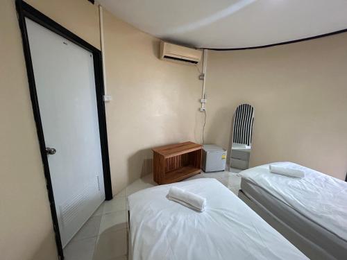 a small room with two beds and a chair at Soukaina Beach Bungalow in Ko Phangan