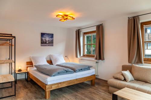 um quarto com uma cama e um sofá em Ferienwohnung Leberkas Hotspot 1og em Ehrwald