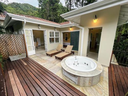 porche con bañera en una terraza de madera en Hospedaria Vila Serra da Luz en Pindamonhangaba