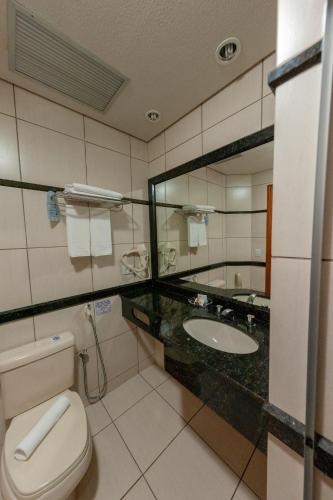 a bathroom with a toilet and a sink at Hotel Executive Arapongas in Arapongas