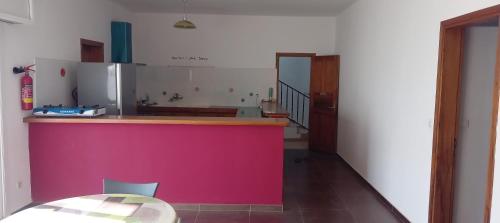a kitchen with a pink counter and a table at L'essentiel nianing in Mbour