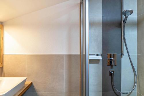 a shower with a glass door in a bathroom at Appartement by Blahut Vacation - dg in Ehrwald