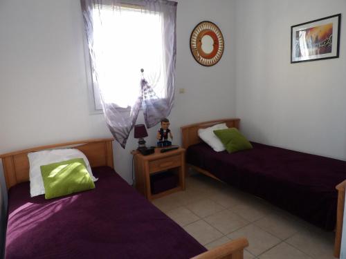 une chambre avec deux lits et une fenêtre dans l'établissement St Cyprien Standing confort et piscine, à Saint-Cyprien