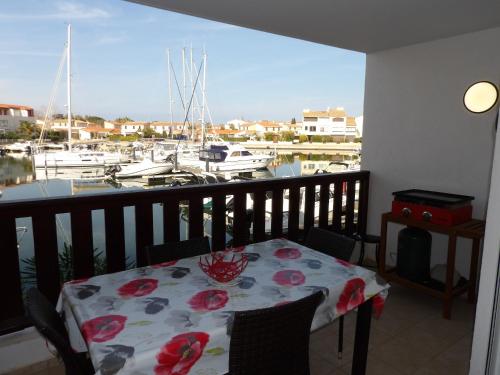 d'un balcon avec une table et une vue sur le port de plaisance. dans l'établissement St Cyprien Standing confort et piscine, à Saint-Cyprien