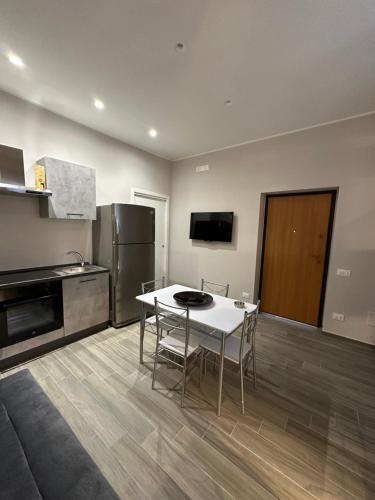 cocina con mesa blanca y nevera en Dimora Gaudiano, en Matera