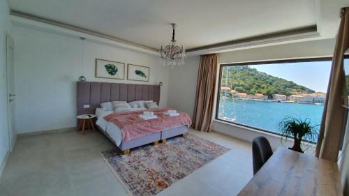 ein Schlafzimmer mit einem Bett und einem großen Fenster in der Unterkunft Guesthouse Augusta Insula in Lastovo