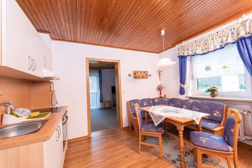 a kitchen and dining room with a table and chairs at Haus am Wald in Bad Koetzting