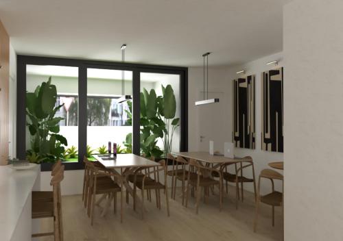 une salle à manger avec une table et des plantes dans l'établissement El Refugi de Girona, à Gérone