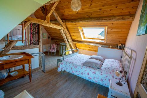 a bedroom with a bed and a sink in a cabin at Chambre d'hôtes - Le jardin des Patissons in La Foret Du Parc