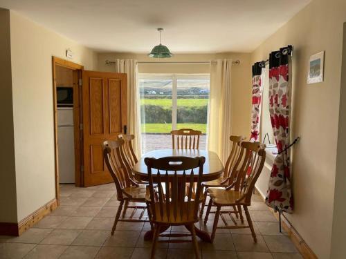 a kitchen and dining room with a table and chairs at 1 Bray Head View in Portmagee