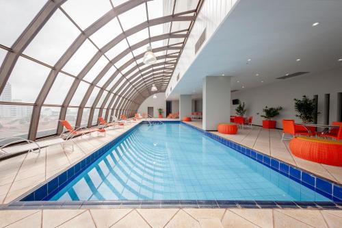 una gran piscina cubierta con techo de cristal en Hotel Executive Arapongas, en Arapongas