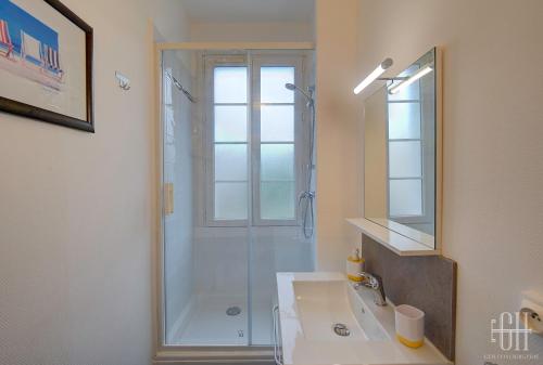 a bathroom with a shower and a sink and a mirror at L'Agapanthe - Proche Gare in Saint-Pierre-des-Corps