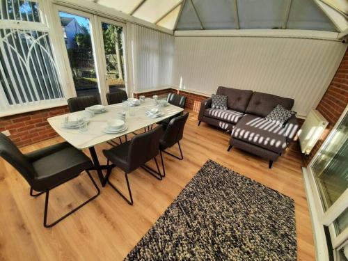 a living room with a table and chairs and a couch at Stunning 5-bed ensuite House Solihull in Solihull