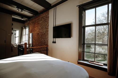 a bedroom with a bed and a large window at De Koepoort in Middelburg