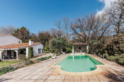 une piscine dans une cour à côté d'une maison dans l'établissement Villa Triptyque - Avec piscine et grand jardin, à Villecroze