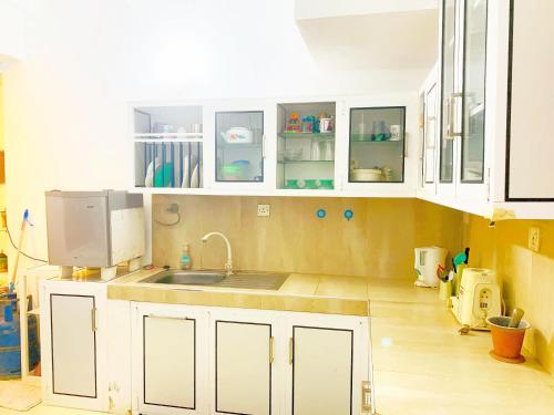 a kitchen with white cabinets and a sink at Matara Near Polhena & Mirissa Three Story House in Matara
